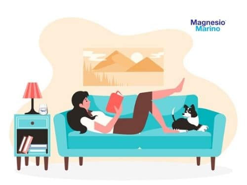 Donna si rilassa sul sofà dopo aver bevuto un bicchiere di Magnesio Marino®
