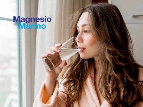 Donna accaldata beve un bicchiere d'acqua