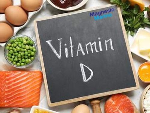 Lavagna con al centro scritto in gesso "Vitamin D" circondata da alimenti contententi al Vitamina D.